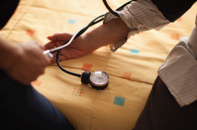 Imagen de una enfermera midiendo la presión a una persona mayor en Cohabitam